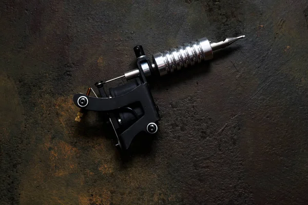 tattoo machine, tattoo gun on rusty metal background