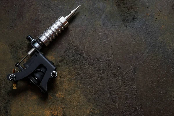 tattoo machine, tattoo gun on rusty metal background