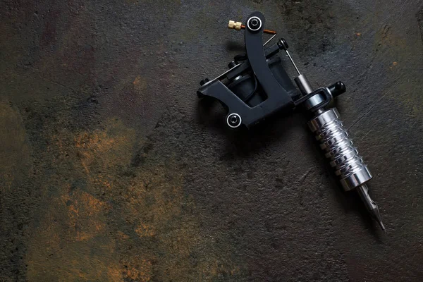 Dövme makinesi, paslı metal arka planda dövme silahı.