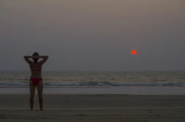 La chica en la orilla del mar observa una puesta de sol — Foto de Stock