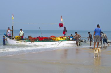 Balıkçılar deniz kıyısı üzerinde tekne donatmak