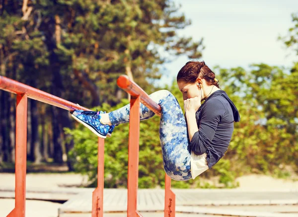 Mulher fazendo exercícios abdominais fora — Fotografia de Stock