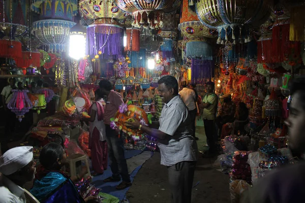 インドのディワリ祭販売中に 店主とその家族が店内に伝統的なランタンを配置します — ストック写真