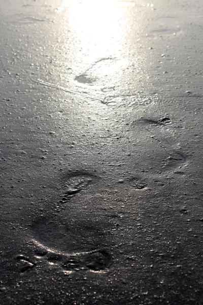 Human left behind in footprints imprinted in sand — Stock Photo, Image