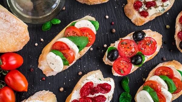 Bruschettas with tomatoes, herbs and olives — Stock Photo, Image