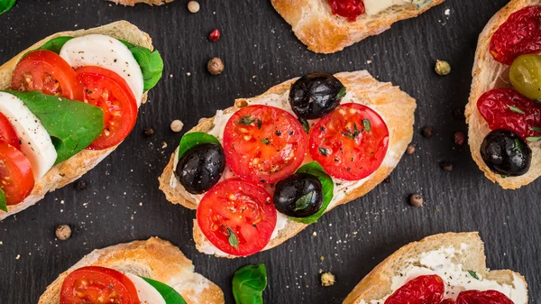 Bruschettas with tomatoes, herbs and olives — Stock Photo, Image