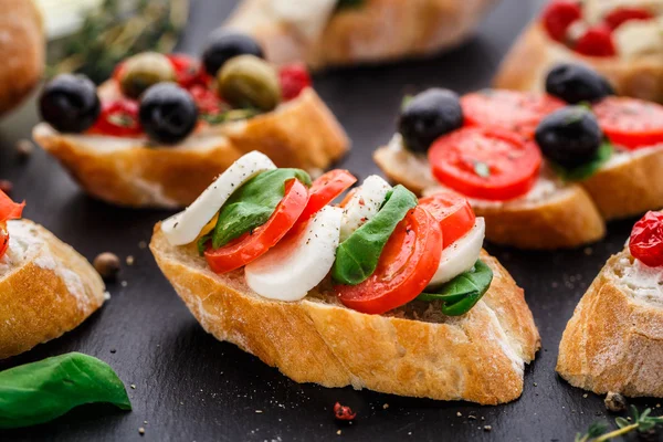 Bruschetta with tomatoes, mozzarella and basil — Stock Photo, Image