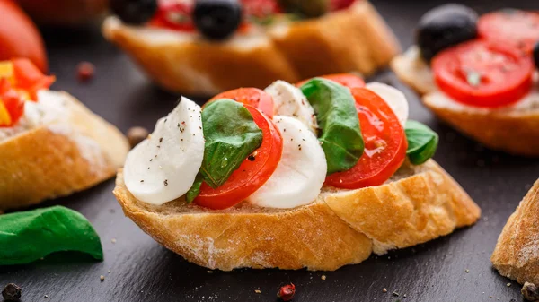 Bruschetta with tomatoes, mozzarella and basil — Stock Photo, Image