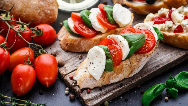 Bruschetta s rajčaty, mozzarellou a bazalkou — Stock fotografie