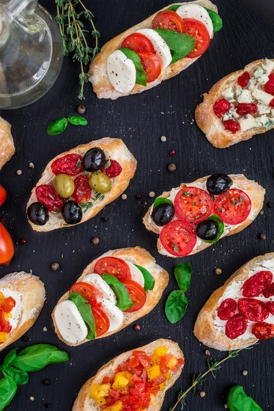 Bruschettas with tomatoes, herbs and olives — Stock Photo, Image