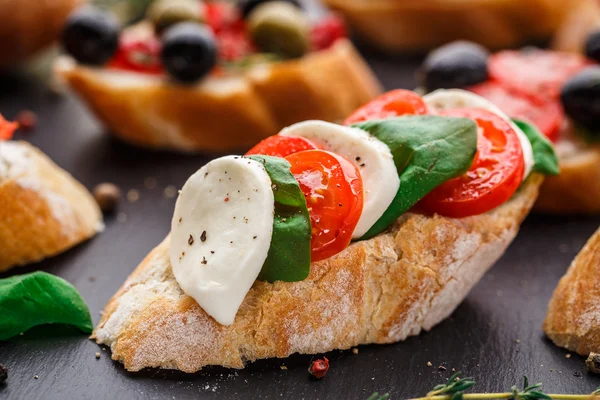 Bruschetta com tomate, mussarela e manjericão — Fotografia de Stock