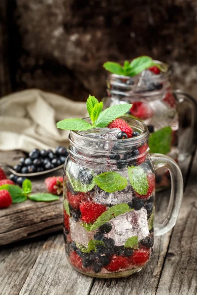 Bebida de desintoxicación con bayas frescas en frascos de vidrio — Foto de Stock