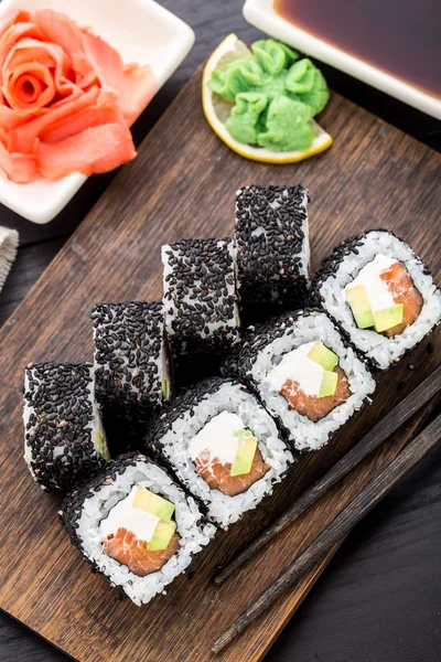 Rolo de sushi de salmão coberto com gergelim — Fotografia de Stock