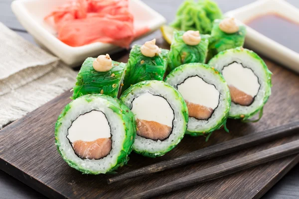 Sushi rolls covered with chuka — Stock Photo, Image