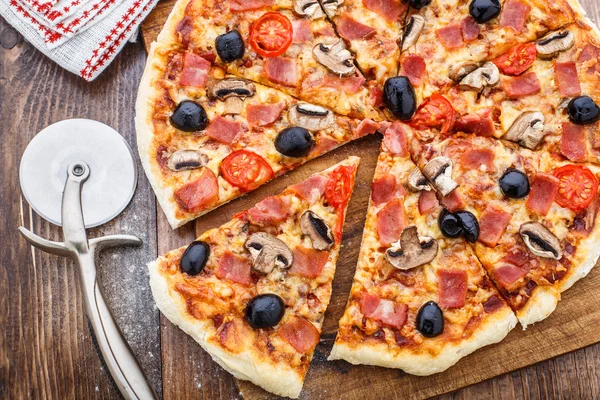 Pizza z szynką, pieczarkami i oliwkami — Zdjęcie stockowe