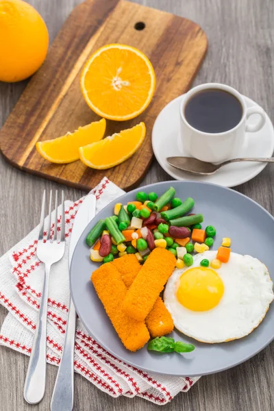 Palitos de peixe, ovo frito e legumes — Fotografia de Stock