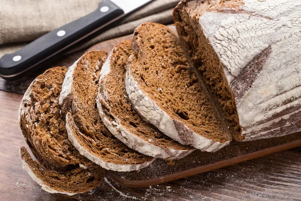 Frisch gebackenes Brot auf Holztisch — Stockfoto