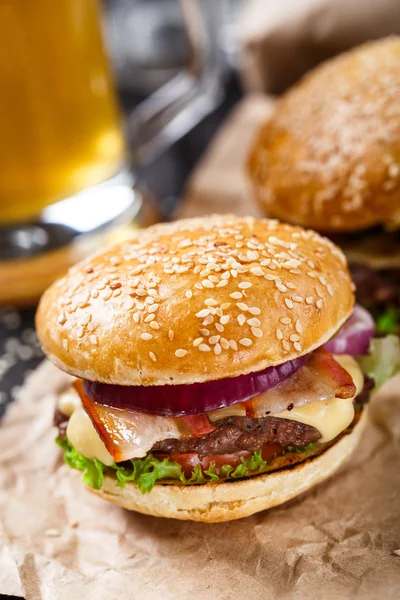 Deliciosa hamburguesa sobre tabla de madera — Foto de Stock