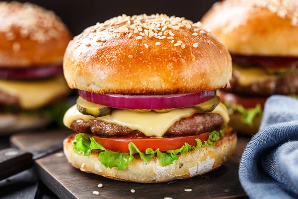 Delizioso hamburger su tavola di legno — Foto Stock