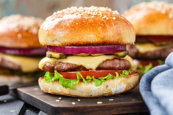 Delizioso hamburger su tavola di legno — Foto Stock