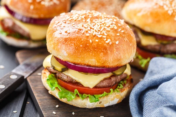 Deliciosa hamburguesa sobre tabla de madera — Foto de Stock