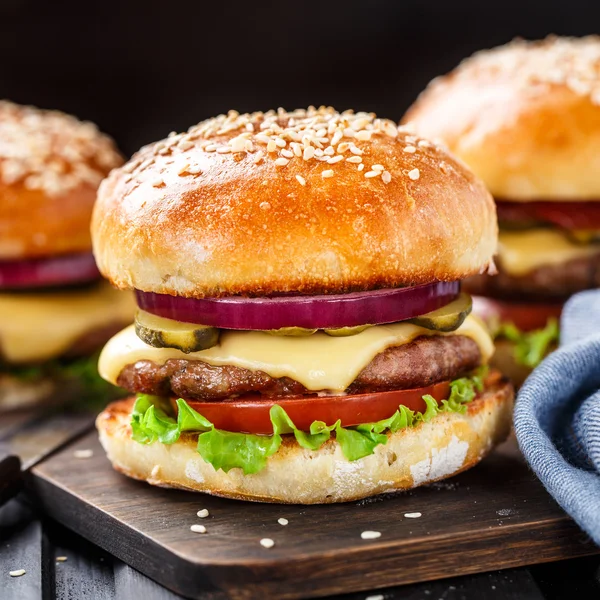 Deliciosa hamburguesa sobre tabla de madera —  Fotos de Stock