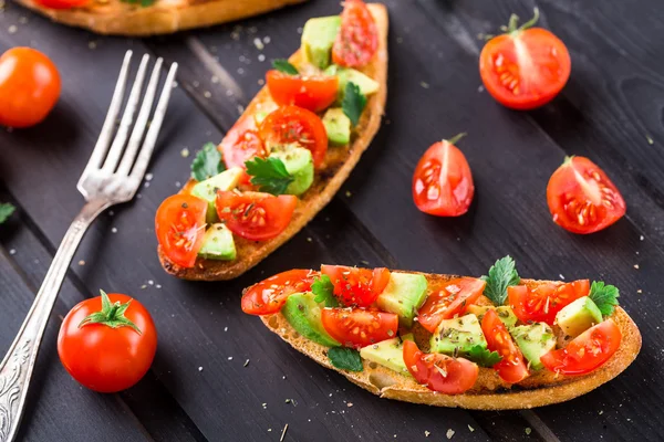 Bruschetta met tomaat, avocado en kruiden — Stockfoto