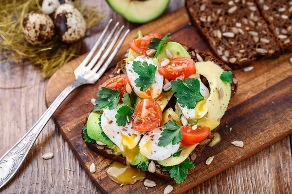 Bruschetta med tomat, avokado och vaktel ägg — Stockfoto