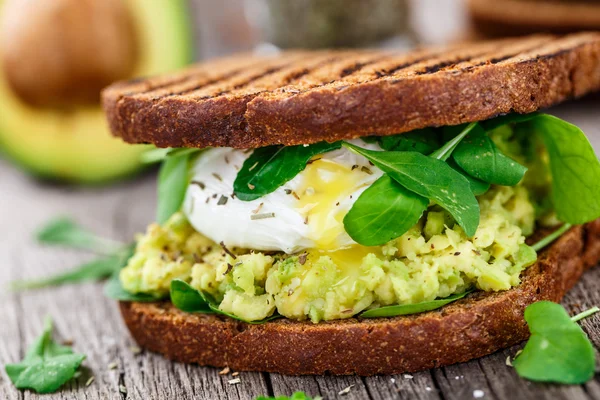 Smörgås med avocado och pocherat ägg — Stockfoto