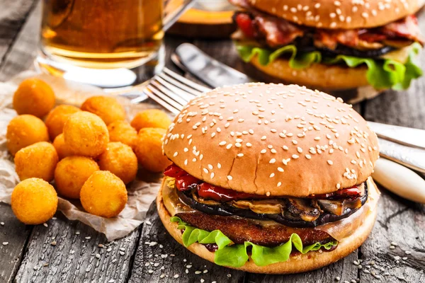 Delicioso hambúrguer com bolas de batata frita e cerveja — Fotografia de Stock