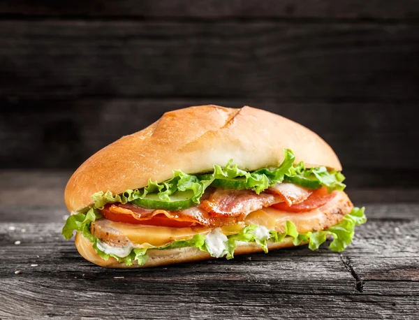 Бутерброд з куркою, беконом та овочами — стокове фото