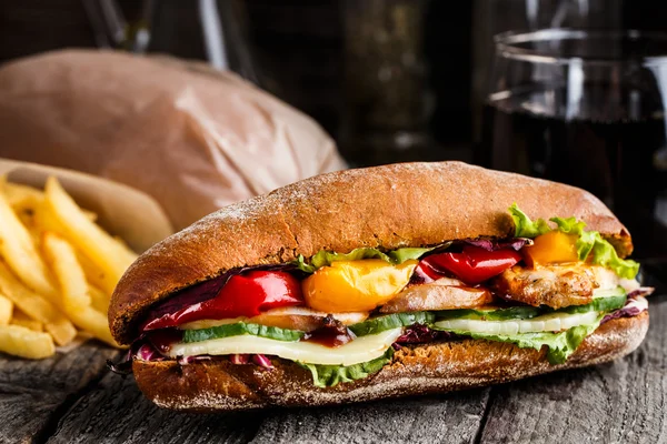 Sanduíche de frango, batatas fritas e copo de refrigerante — Fotografia de Stock