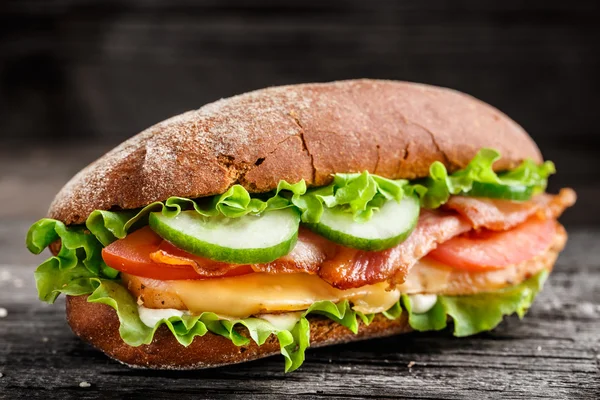 Sanduíche com frango, queijo bacon e legumes — Fotografia de Stock