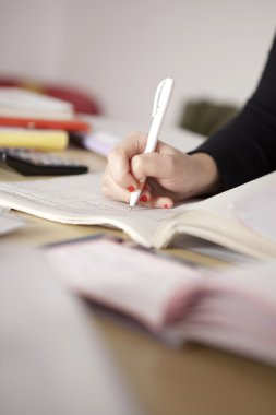 birkaç kağıt üzerinde çalışıyor.