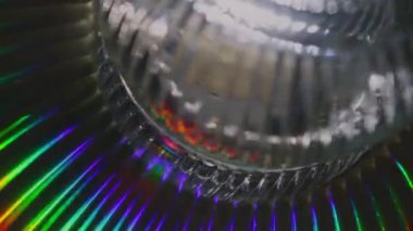 Dönen bir cam nesnenin büyüleyici kusursuz döngüsü canlı holografik gökkuşağı ışınlarını kırıyor. Fütürist, bilim kurgu atmosferi teknoloji, müzik veya parti görselleri için mükemmeldir..
