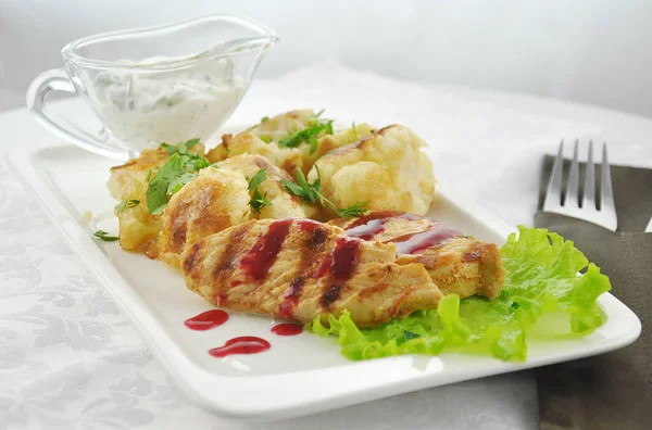 Beyaz arka planda karnabaharlı hindi bifteği.