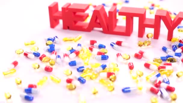 Состав здорового знака с красочными таблетками — стоковое видео