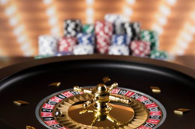 Kumar masasında poker fişleri, hareket halindeki rulet çarkı, kumarhane geçmişi