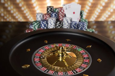Kumar masasında poker fişleri, hareket halindeki rulet çarkı, kumarhane geçmişi