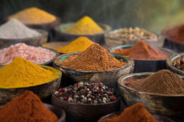 Çeşit çeşit baharatlar ve ahşap bir kase duman.