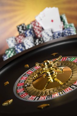 Kumar masasında poker fişleri, hareket halindeki rulet çarkı, kumarhane geçmişi