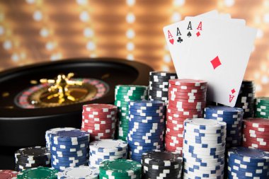 Kumar masasında poker fişleri, hareket halindeki rulet çarkı, kumarhane geçmişi