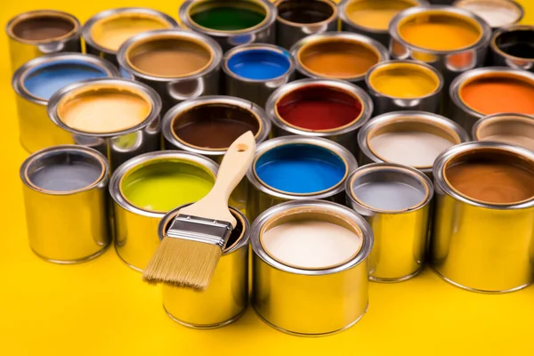 Metal tin cans with color paint and paintbrush