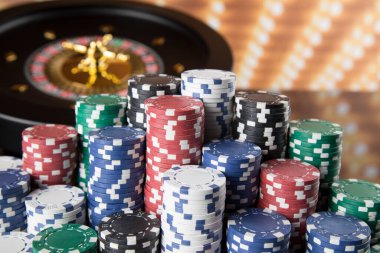 Kumar masasında poker fişleri, hareket halindeki rulet çarkı, kumarhane geçmişi