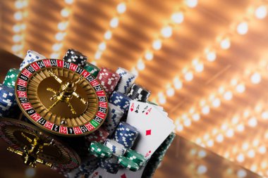 Kumar masasında poker fişleri, hareket halindeki rulet çarkı, kumarhane geçmişi