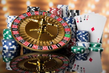 Kumar masasında poker fişleri, hareket halindeki rulet çarkı, kumarhane geçmişi