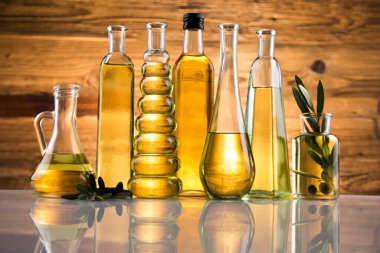 Bir şişe zeytinyağı, zeytin dalı ve pişirme yağı.