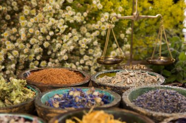 Çeşitli doğal ilaçlar, bitkiler ve havan topları.