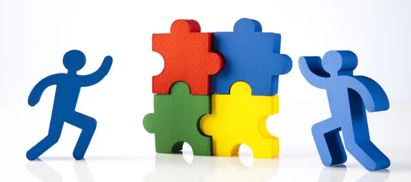 Figures with colorful puzzle pieces — Stock Photo, Image