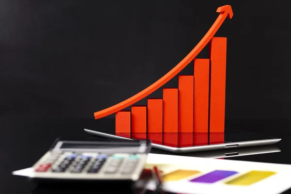 Финансовый график на планшете с калькулятором — стоковое фото